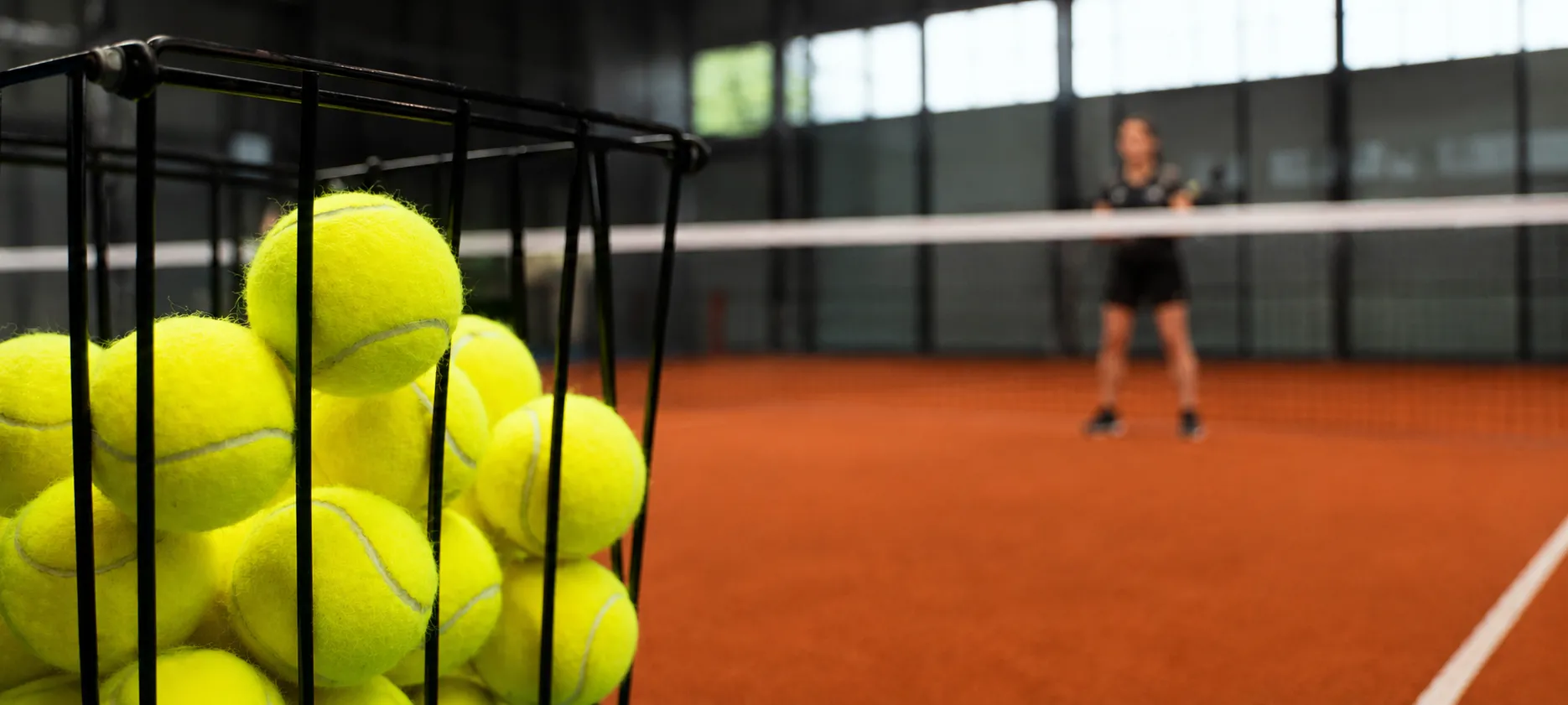 Basket of balls on an indoor padel court
