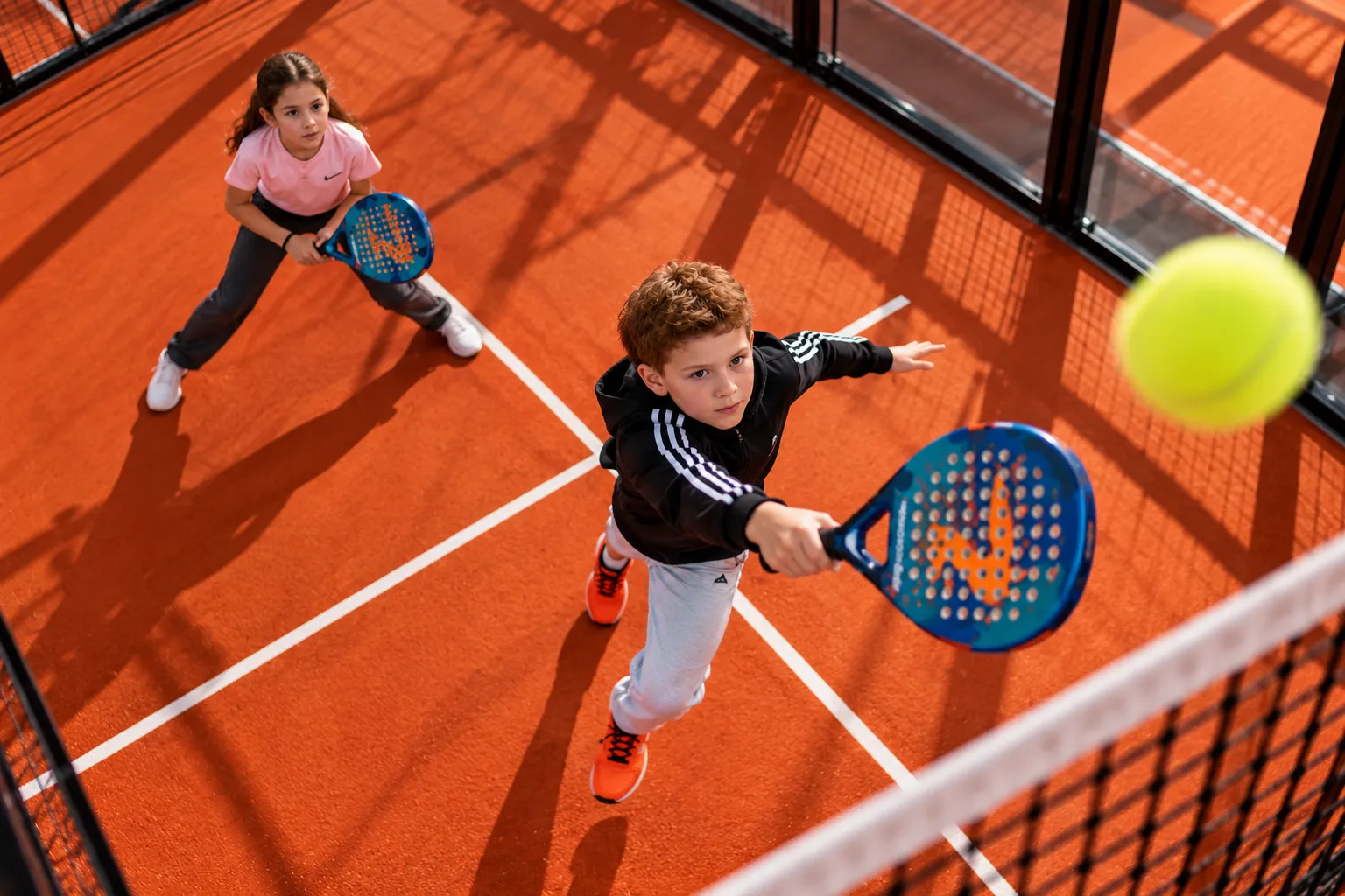 Kids playing padel on an indoor court at Padel Point
